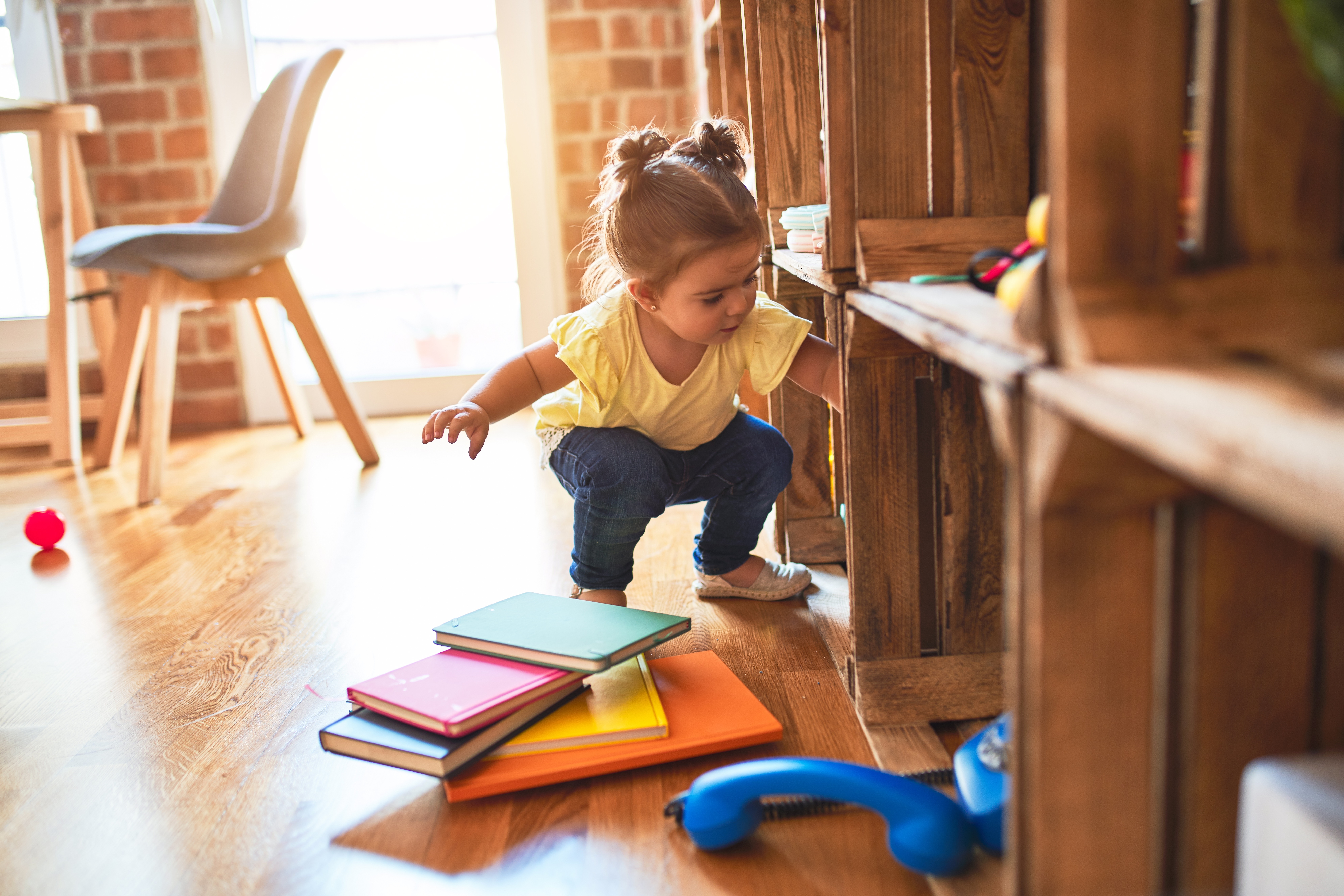 toddler taking books of shelving